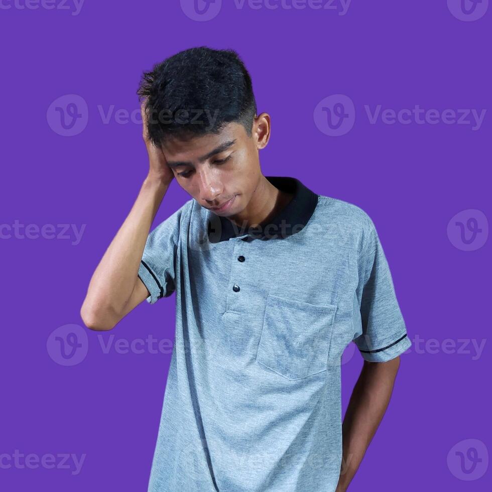schwindlig Gesicht halten Kopf von asiatisch jung Mann im grau T-Shirt. isoliert auf Gelb Hintergrund foto