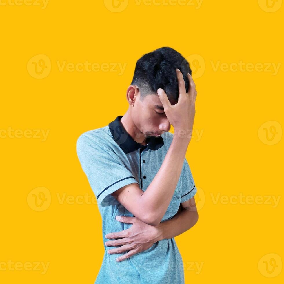 verwirrt asiatisch jung Mann grau T-Shirt, isoliert Gelb Hintergrund foto