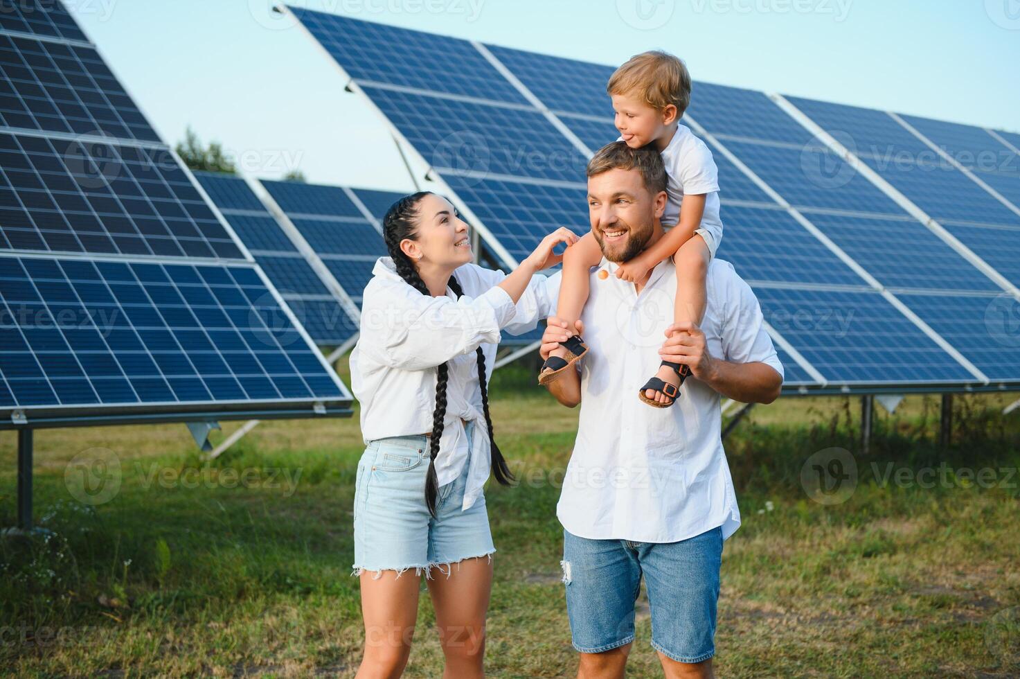 jung Familie von drei ist duckte sich in der Nähe von Photovoltaik Solar- Tafel, wenig Junge und Eltern. modern Familie Konzept. das Konzept von Grün Energie foto