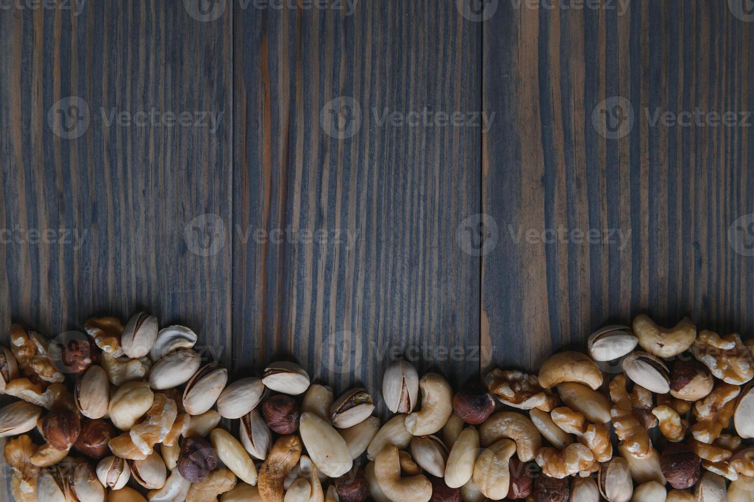 gemischt Nüsse im ein Schüssel auf hölzern Tisch, oben Aussicht mit Kopieren Raum. foto