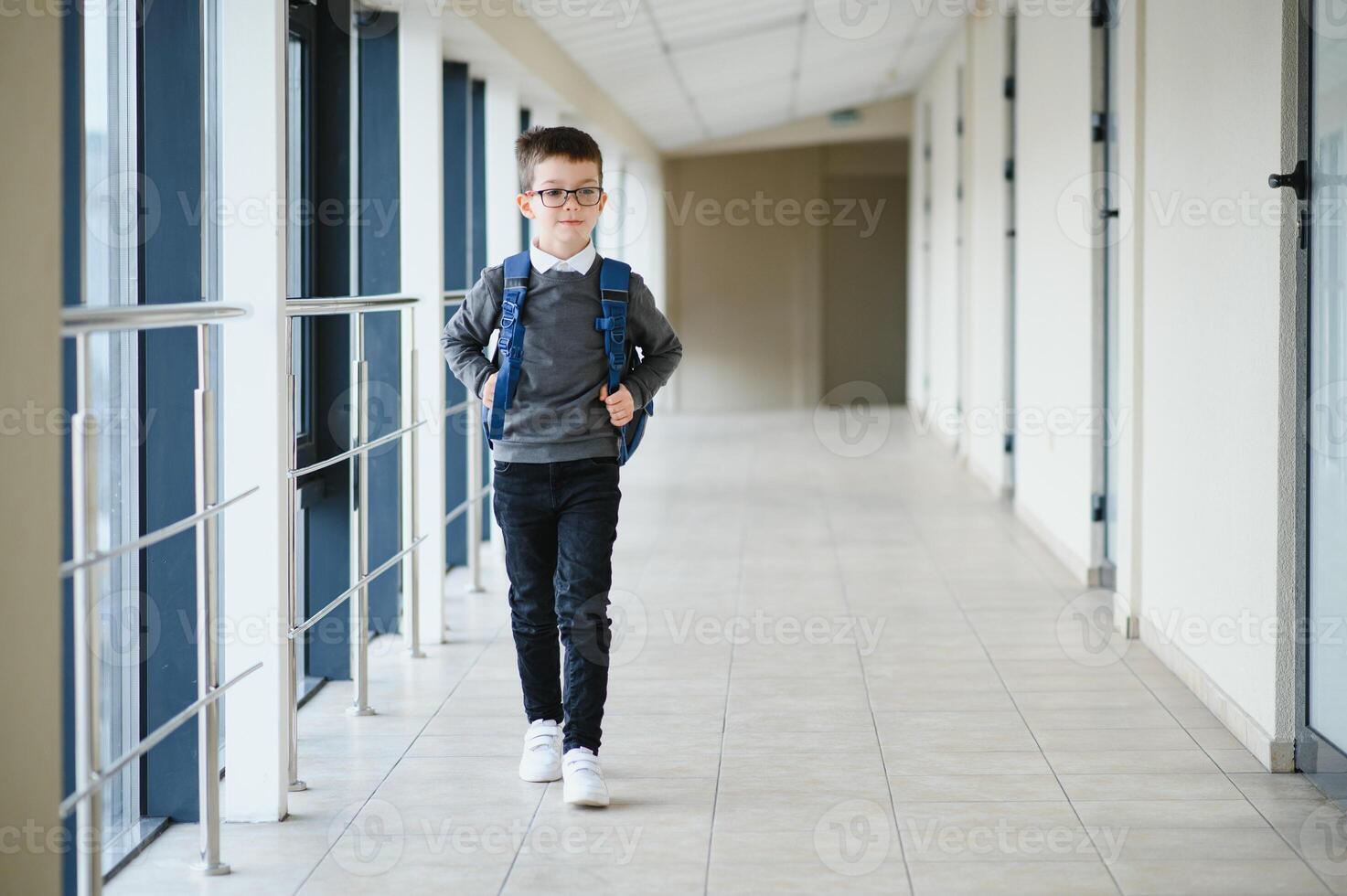 glücklich süß klug Junge im Brille mit Schule Tasche und Buch im seine Hand. zuerst Zeit zu Schule. zurück zu Schule. foto