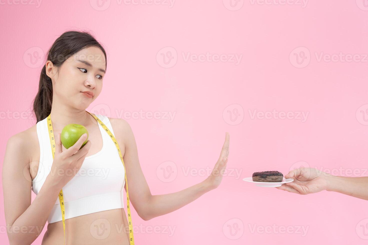 Ernährung und Diät. schönheit schlank weiblicher körper verwirren donut. frau in trainingskleidung erreicht gewichtsverlustziel für ein gesundes leben, verrückt nach dünnheit, dünner taille, ernährungsberaterin. foto