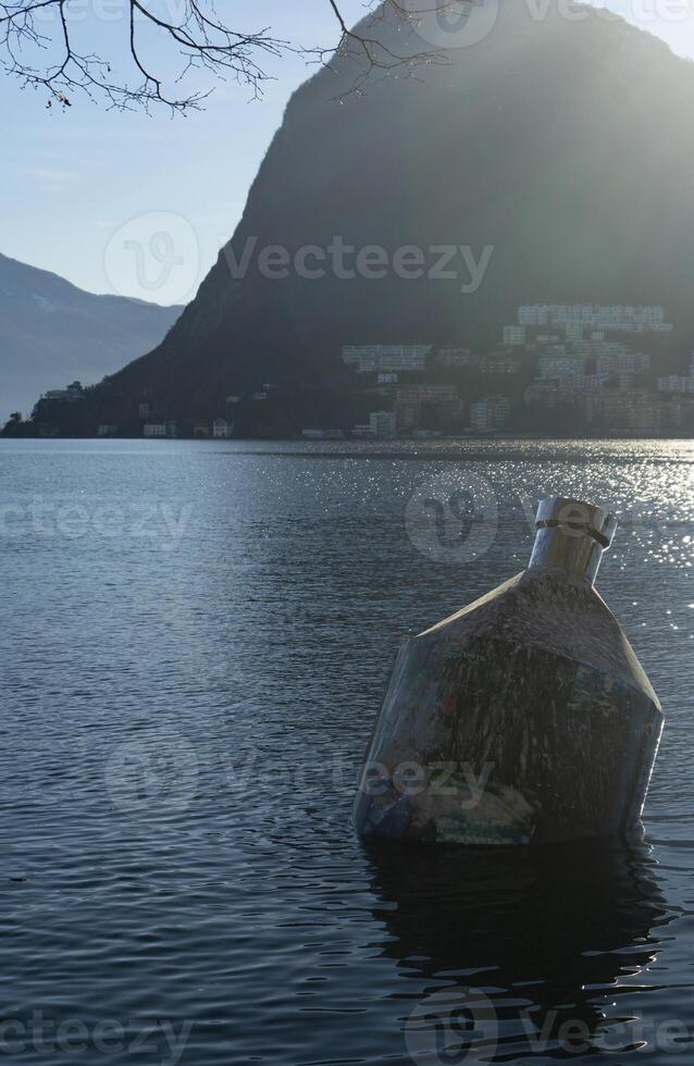 ein groß Statue von Flasche im das Wasser foto