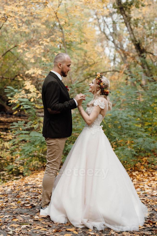 Spaziergang des Brautpaares durch den Herbstwald foto