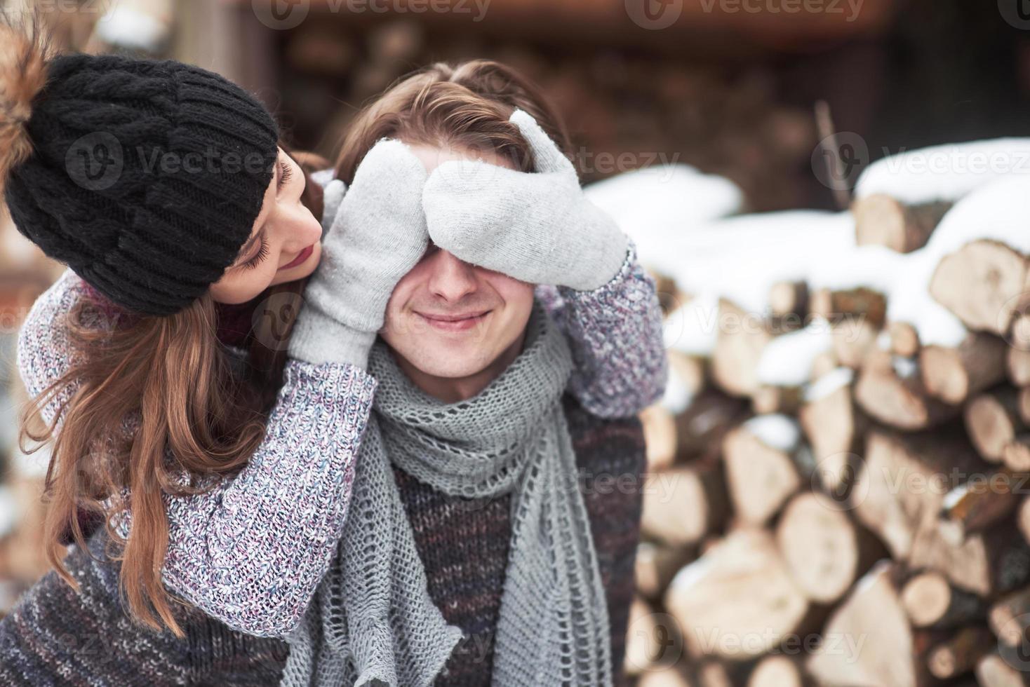 junges fröhliches Paar in einer Hütte in romantischer Landschaft im Winter foto