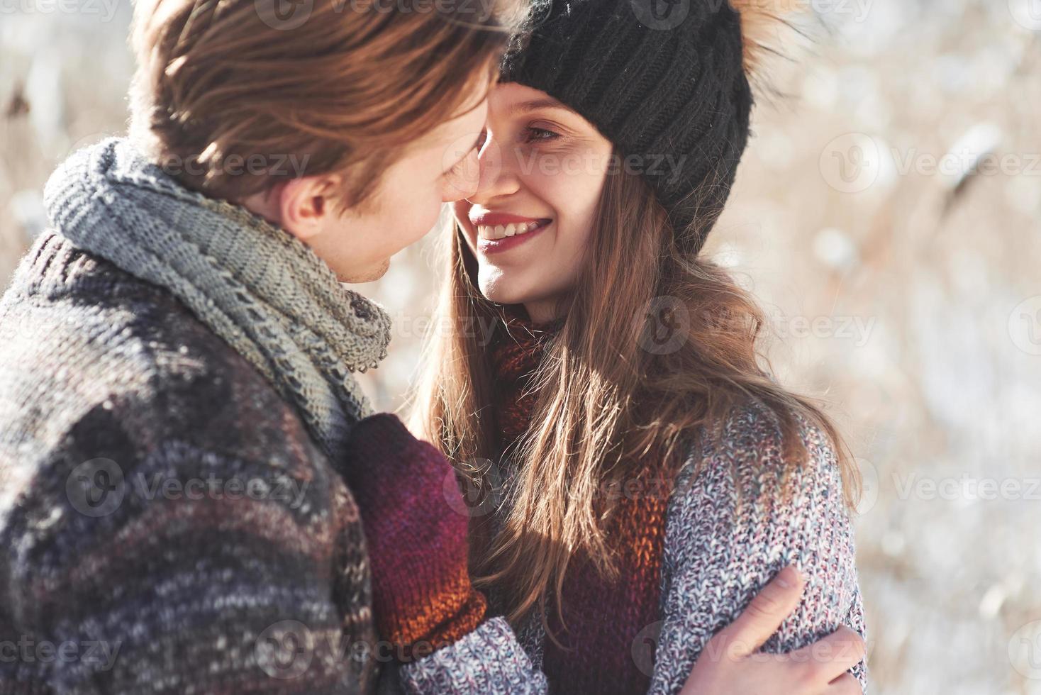 fröhliches junges Paar, das Spaß im Winterpark hat foto