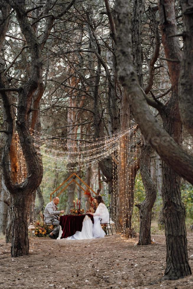 Hochzeitsessen eines frisch vermählten Paares im Herbstwald foto