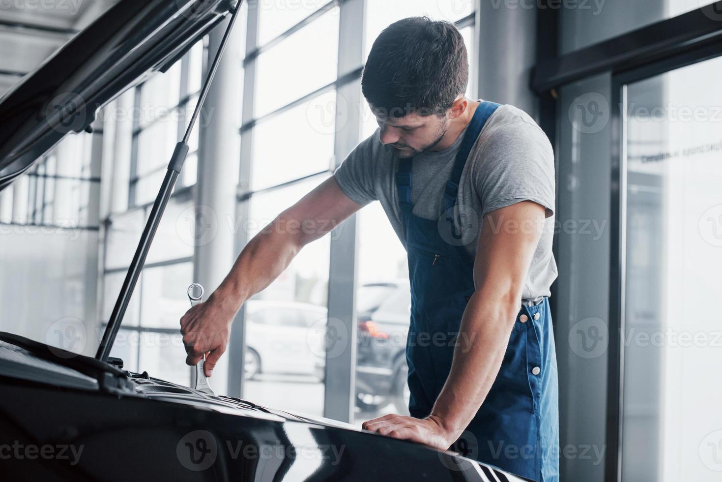 Mechanikerhände, die die Gebrauchstauglichkeit des Autos bei geöffneter Haube überprüfen, Nahaufnahme. foto