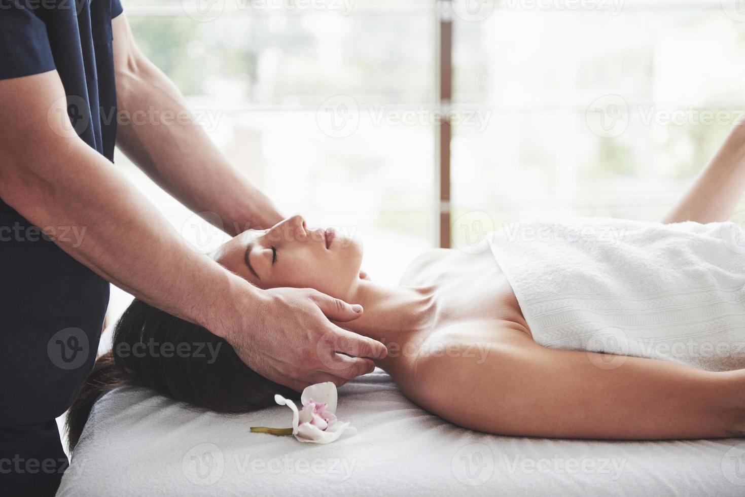 junge schöne Frau, die sich vom Massagegesicht entspannt foto