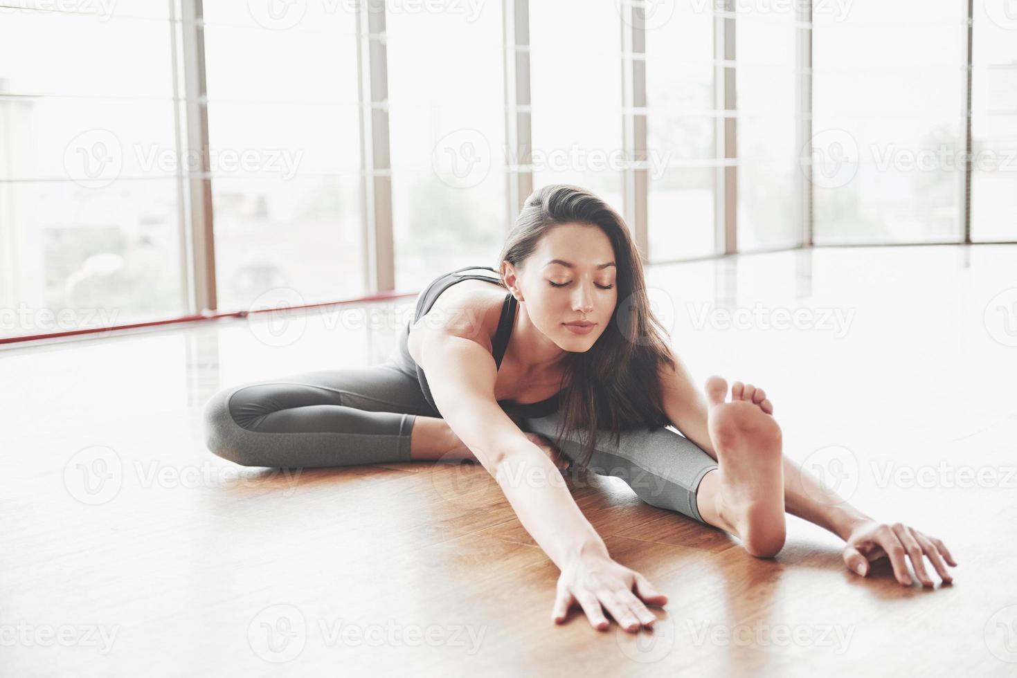 Stretching eine Turnerin macht einen Split, eine Schnur in einer Turnhalle. foto