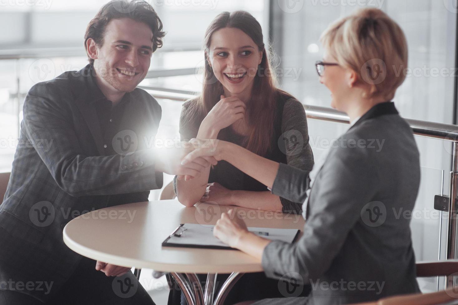 Teamjob erfolgreich. Foto junge Geschäftsleute, die mit einem neuen Startup-Projekt im Büro arbeiten. analysieren Dokument, Pläne. generisches Design-Notizbuch auf Holztisch, Papieren, Dokumenten