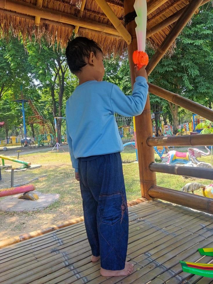 Junge, der sein Schwertspielzeug genießt. Spielzeuggeschäft foto