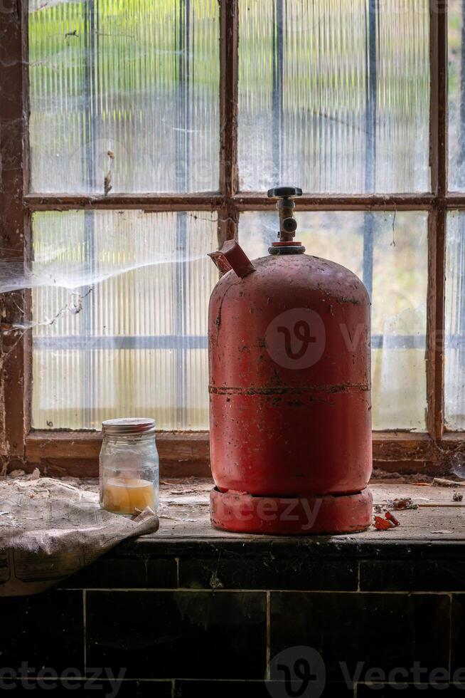 ein alt rot Gas Flasche auf ein Fenster foto