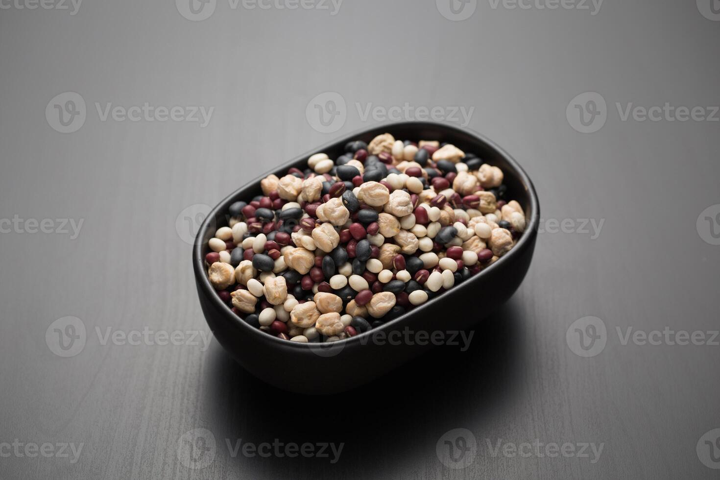 Kichererbsen, schwarz Bohnen, rot Bohnen, Sojabohnen im ein klein schwarz Schüssel. foto