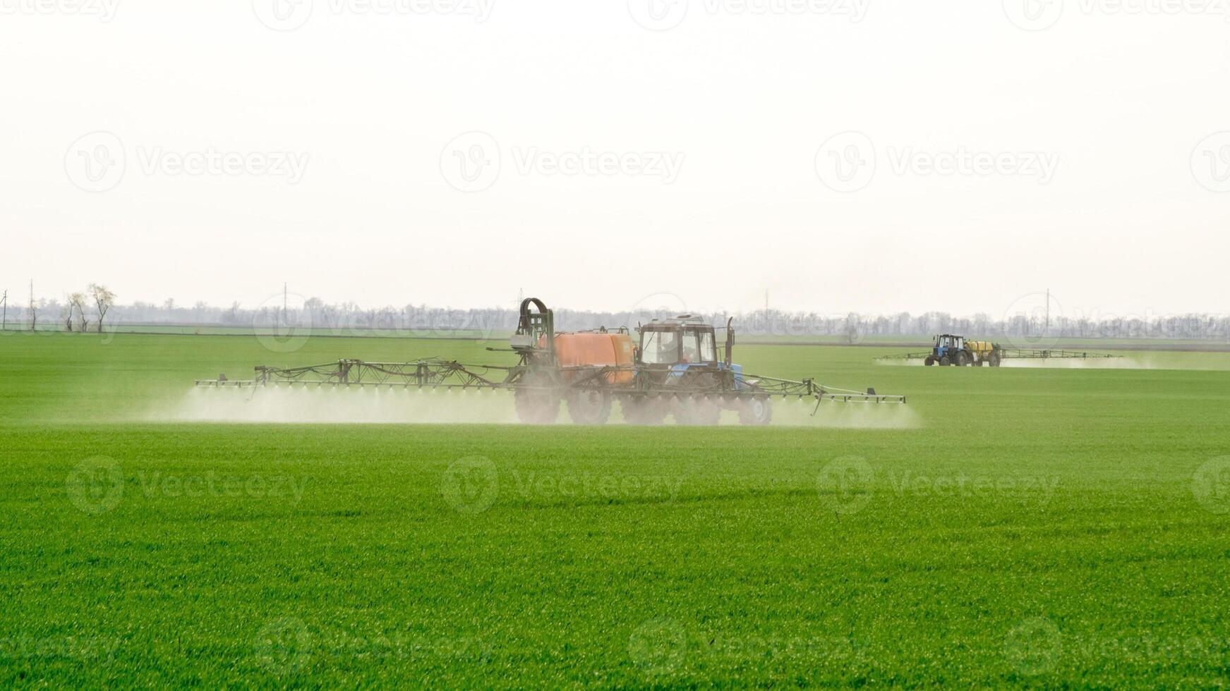 Traktor mit ein sprühen Gerät zum fein dispergiert Dünger. foto