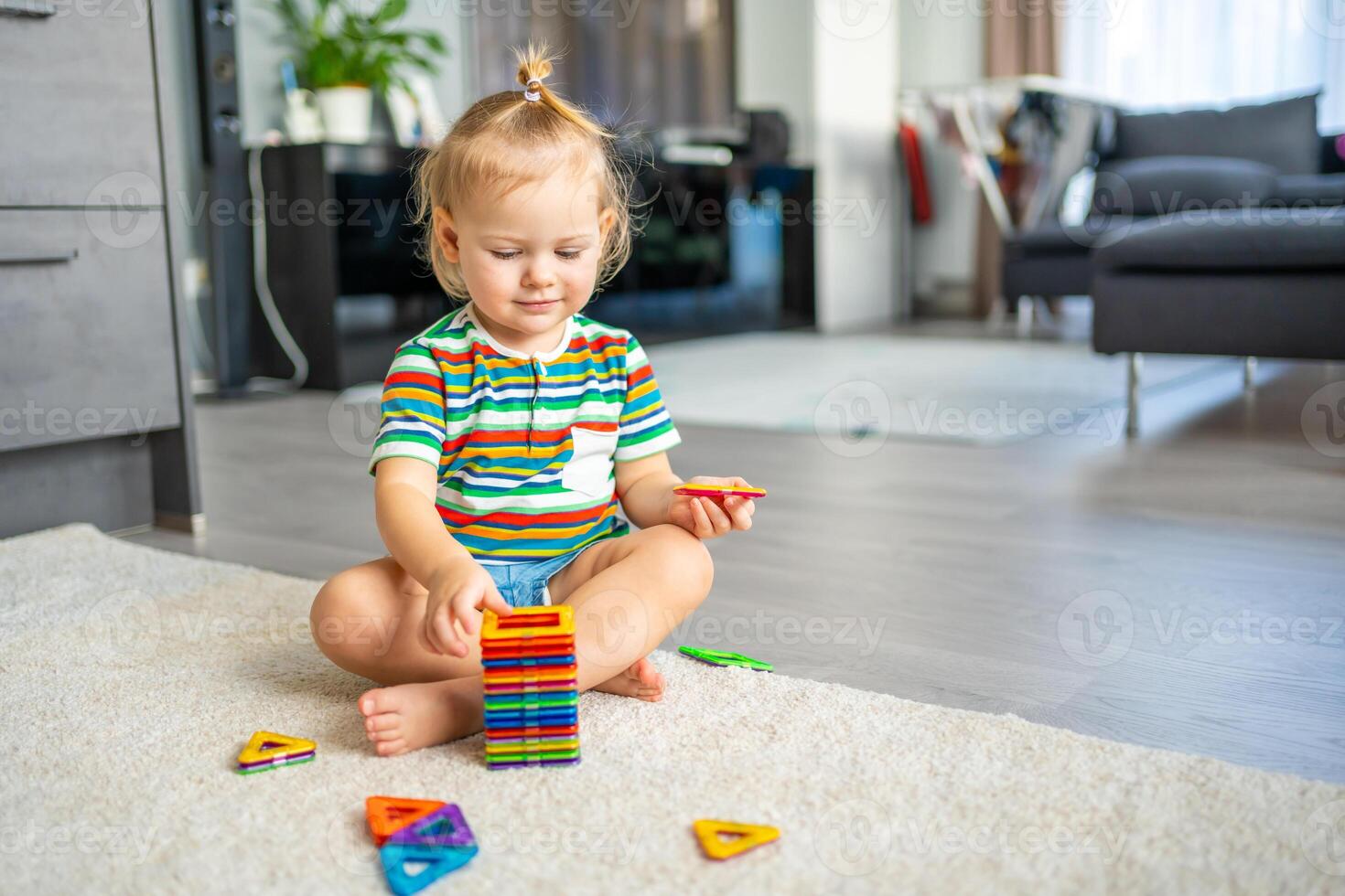 wenig Mädchen spielen bunt Magnet Plastik Blöcke Kit beim heim. das Kind spielen lehrreich Spiele. früh Kindheit Entwicklung. foto