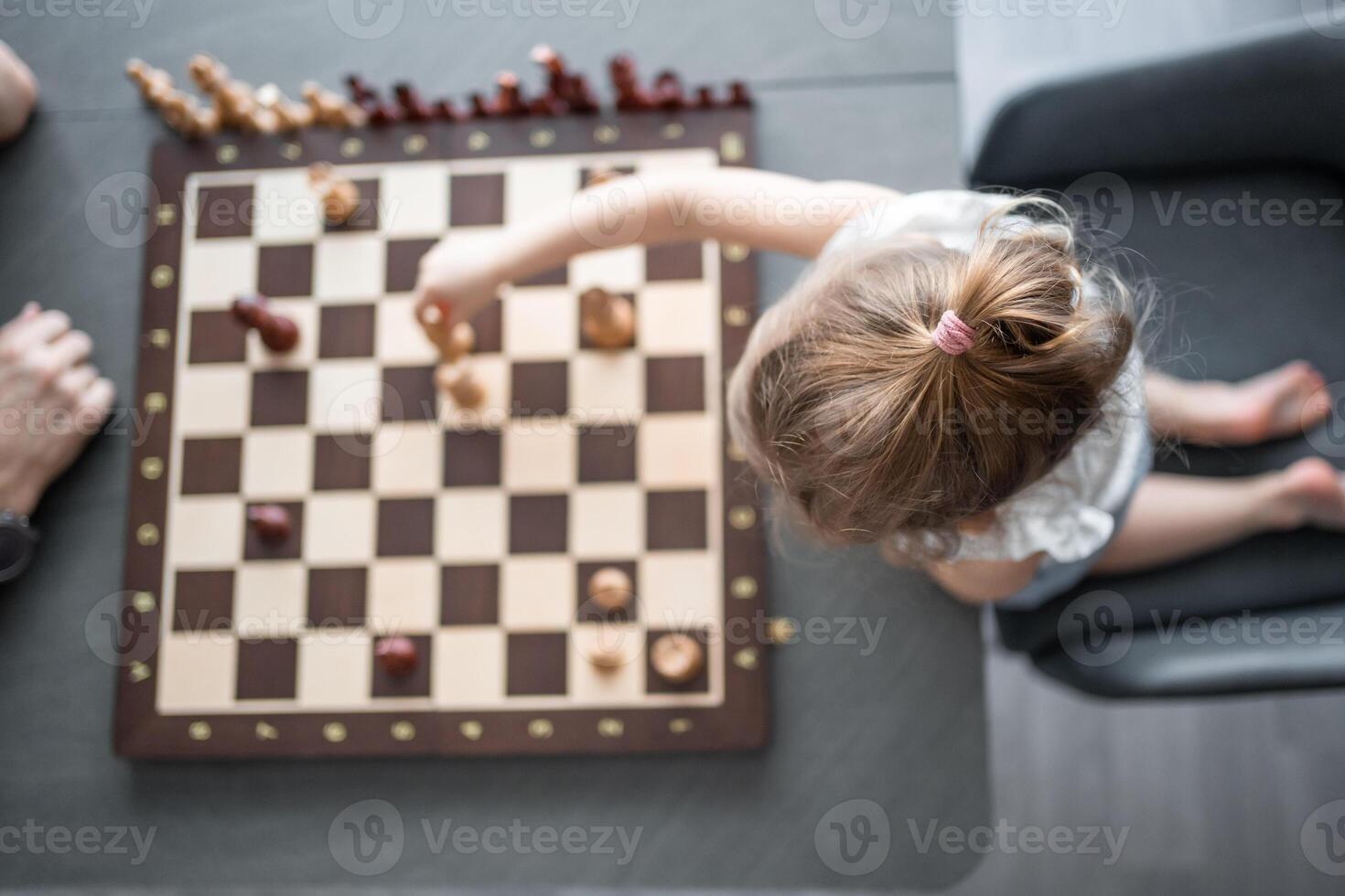 Vater Lehren seine wenig Tochter zu abspielen Schach beim das Tabelle im Zuhause Küche. das Konzept früh Kindheit Entwicklung und Bildung. Familie Freizeit, Kommunikation und Erholung. foto