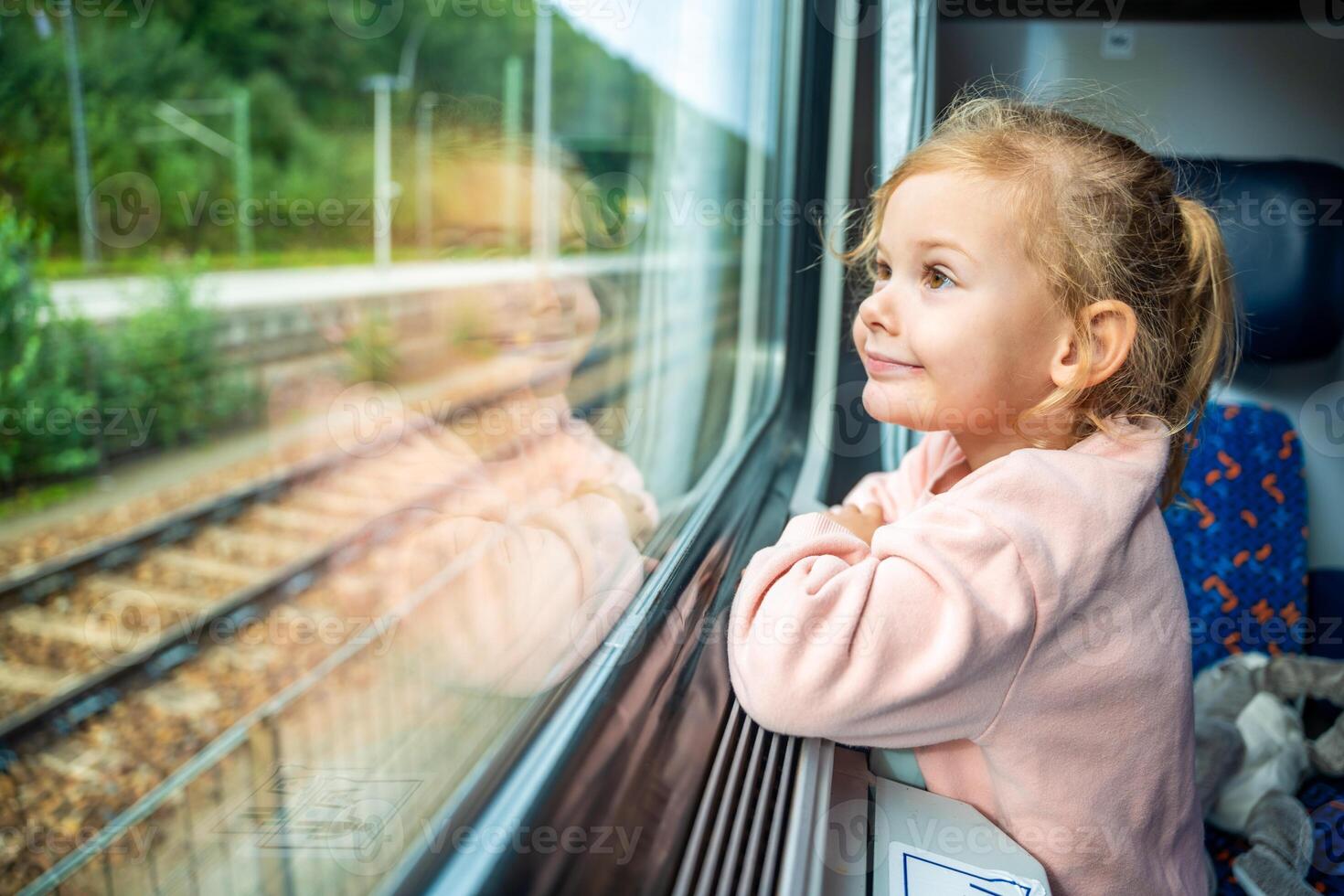 glücklich wenig Mädchen suchen aus Zug Fenster außen, während es ziehen um. Reisen durch Eisenbahn im Europa foto