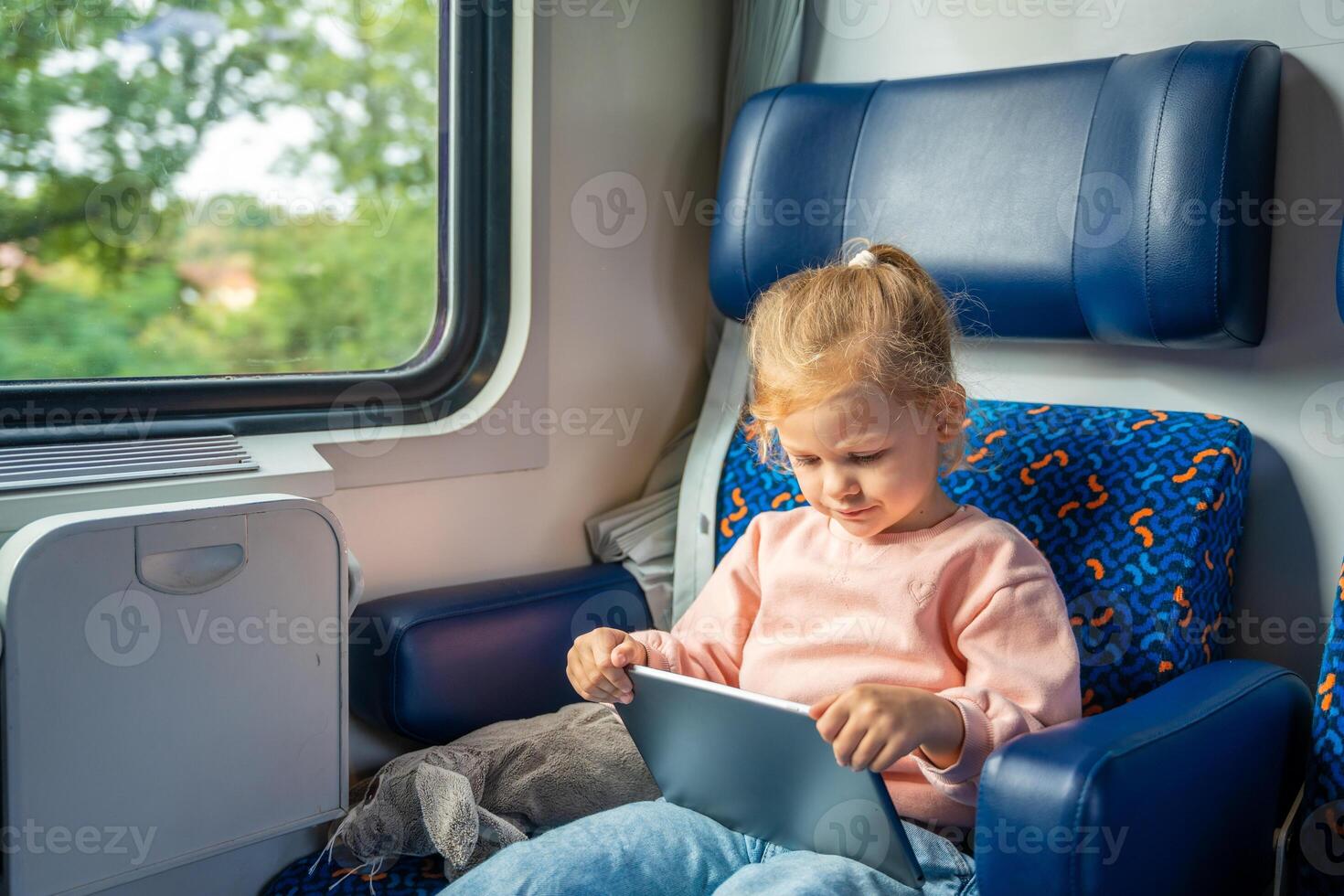 schön wenig Mädchen mit Digital Tablette während Reisen durch Eisenbahn, Europa foto