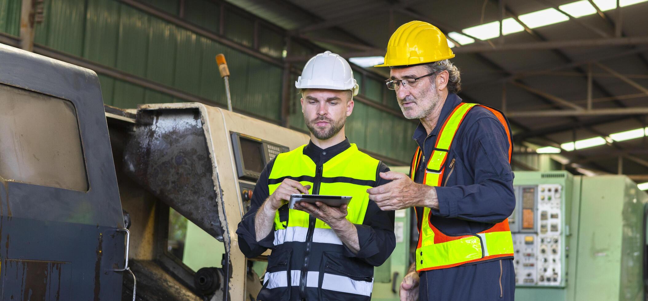 zwei Ingenieur aussehen Projekte und Planung mit Tablette Handy, Mobiltelefon im Fabrik foto