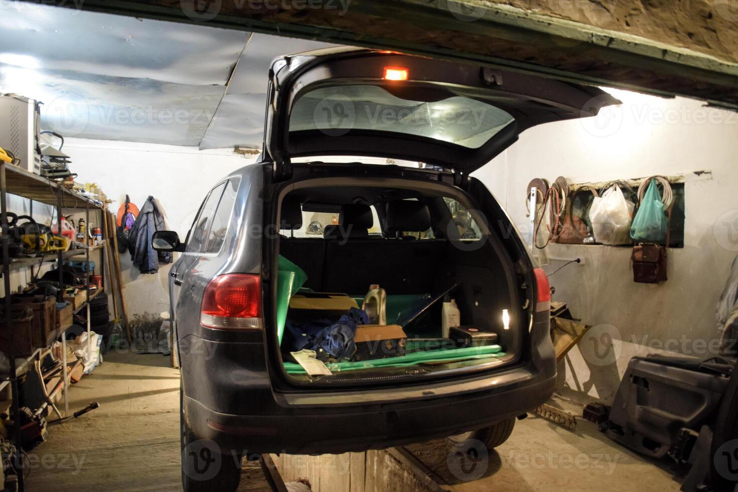 das Volkswagen Auto ist im das Garage mit ein öffnen Stamm. foto