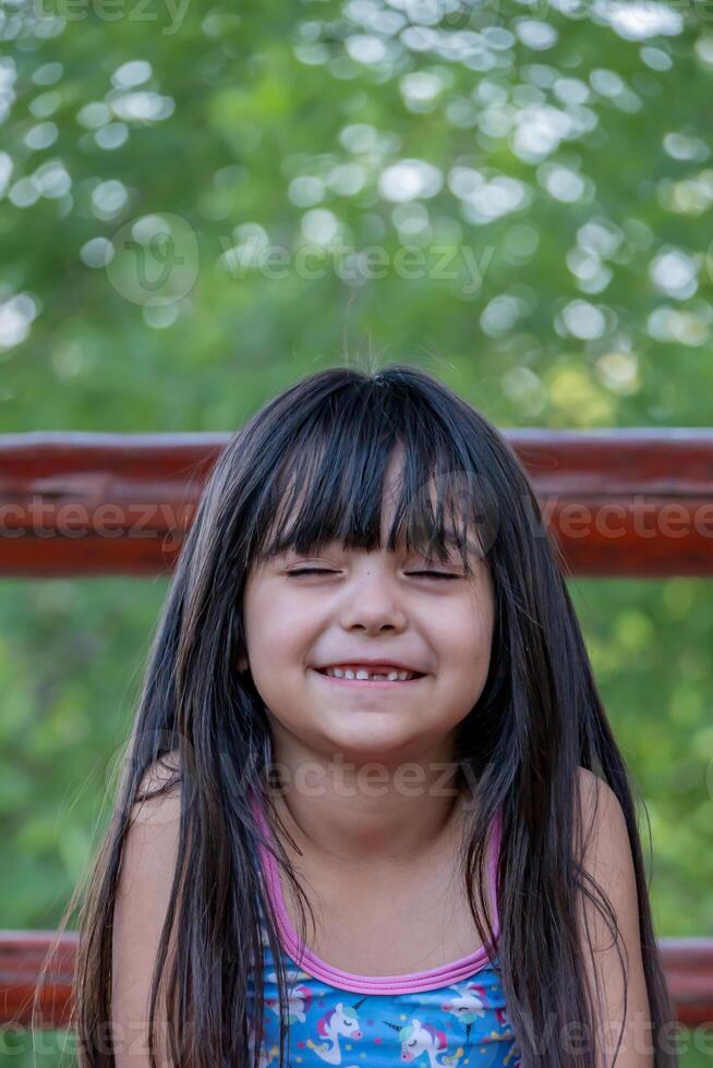 Porträt von ein Latein Mädchen Lachen mit ihr Augen geschlossen. foto