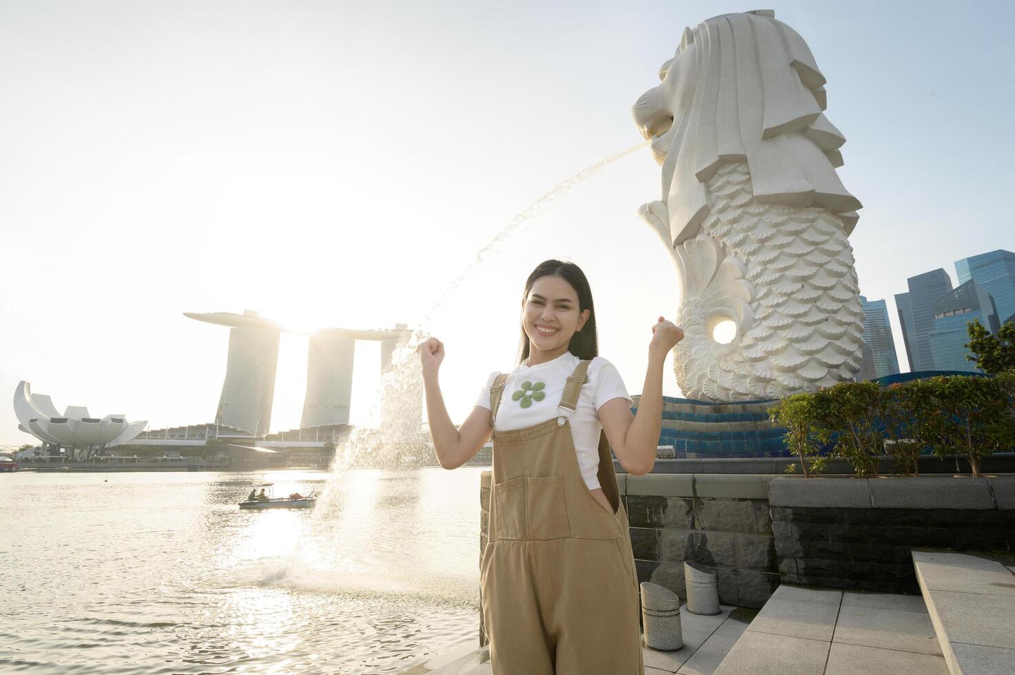 ein Frau im Merlion Brunnen im Vorderseite von das Yachthafen Bucht foto