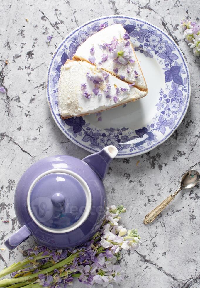 immer noch Leben mit schwarz Tee und Käse Kuchen, Frühling Blumenstrauß, zart lila Blumen foto