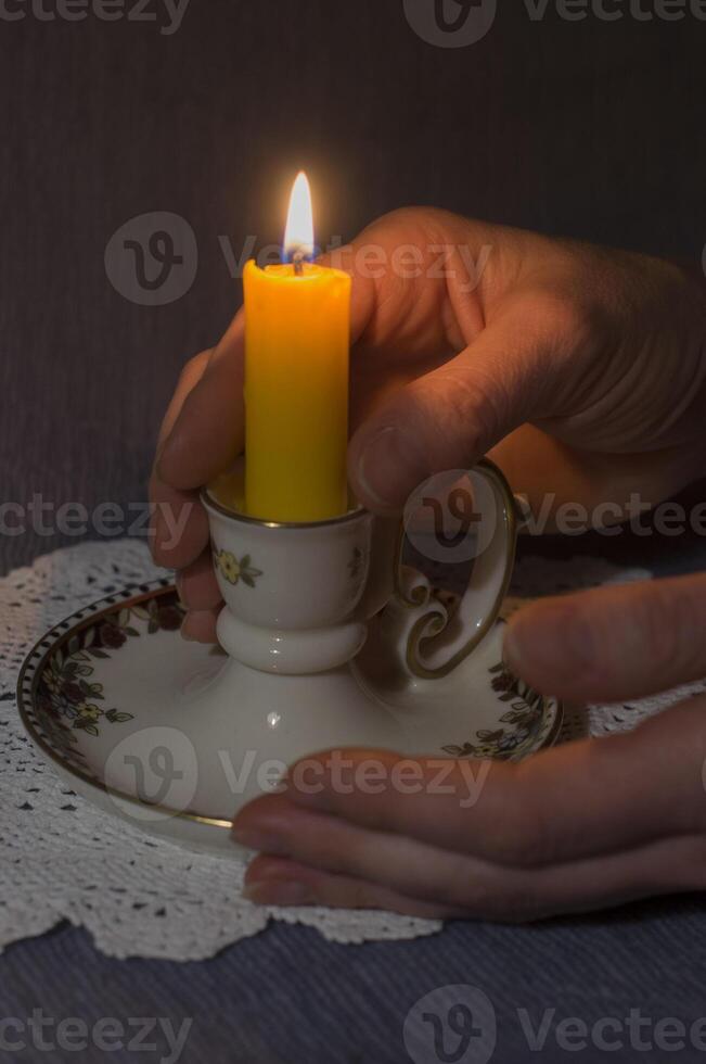 ein zündete Kerze zwischen Damen Palmen im das dunkel Stille und Beileid, foto