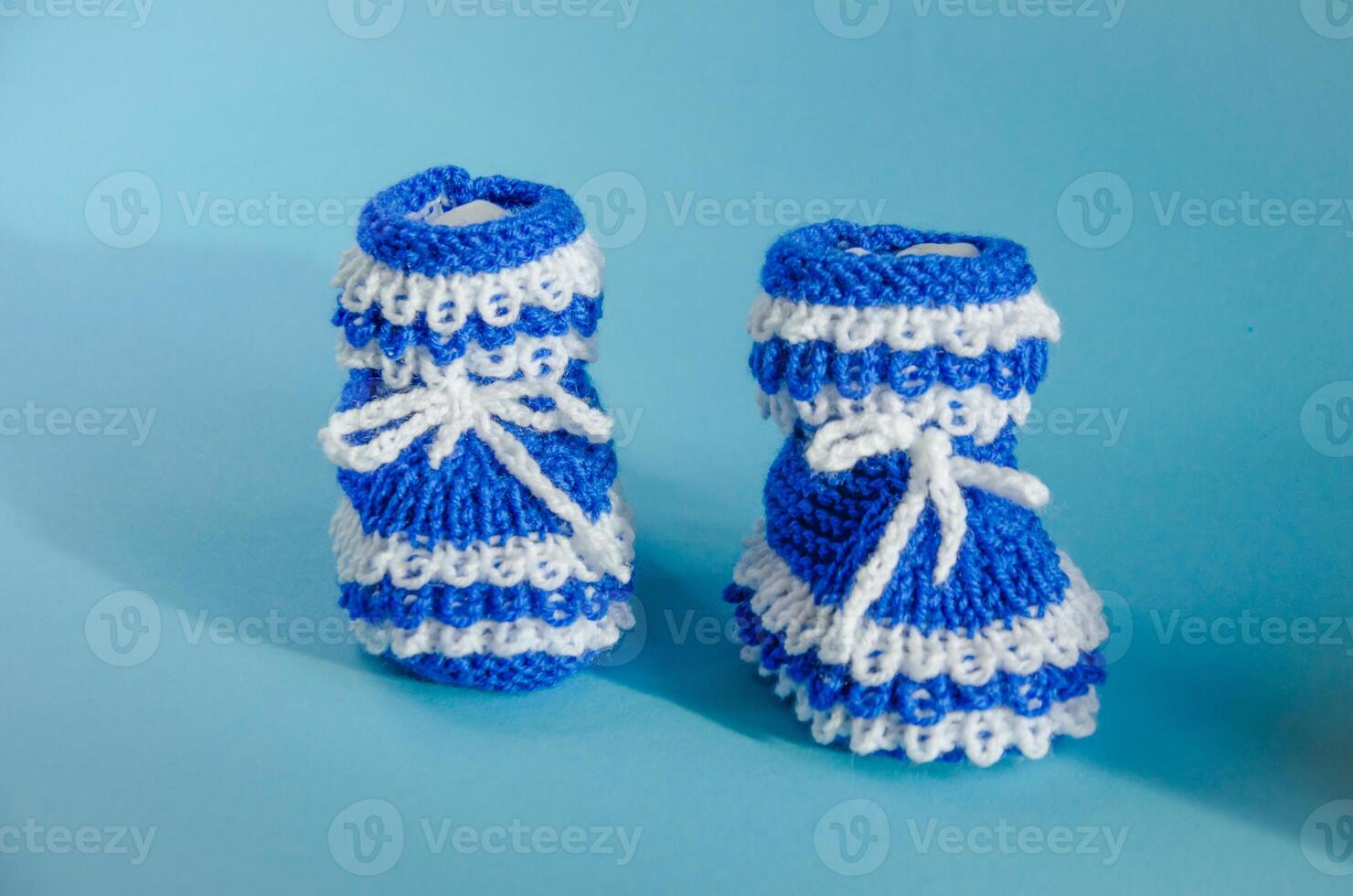 Blau gestrickt Booties auf ein Blau Hintergrund foto