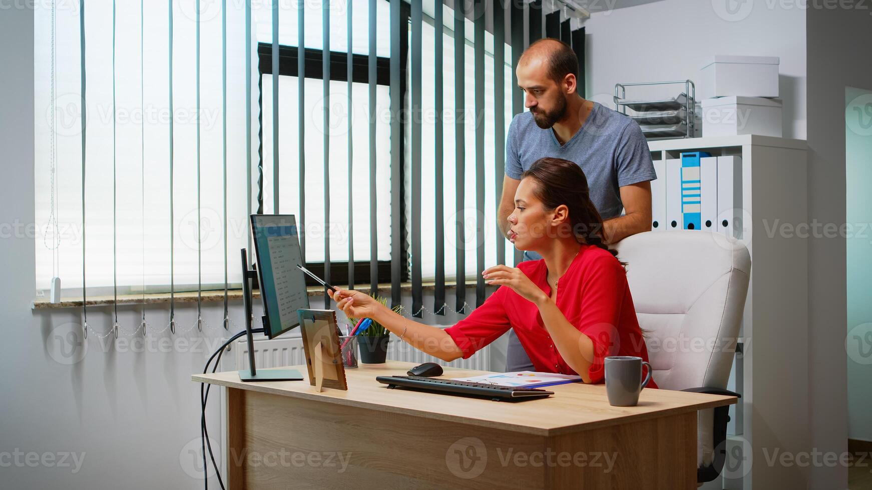 Mann erklären Lösung von Problem zu spanisch Kollege im Vorderseite von Stk. Mannschaft Arbeiten im Fachmann Arbeitsplatz im persönlich korporativ Unternehmen Tippen auf Computer Tastatur suchen zeigen beim Desktop foto