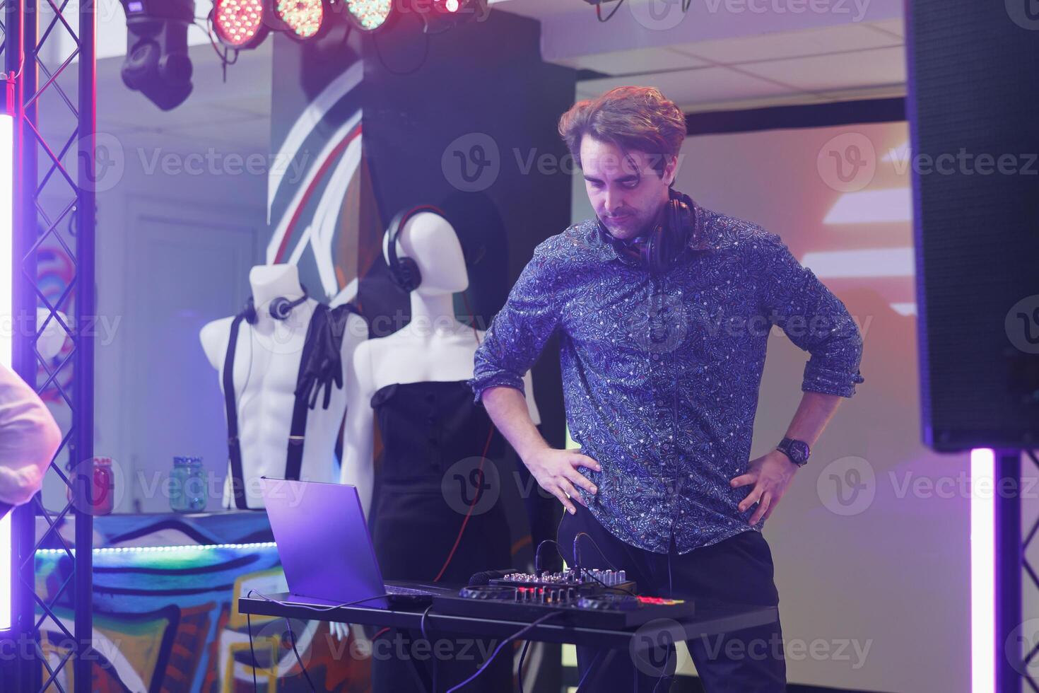 dj Stehen auf Bühne während Mischen Spuren mit Digital Konsole beim Festival im Nachtclub. jung Mann mit elektronisch Musik- Regler und durchführen beim Disko Party Veranstaltung im Verein foto