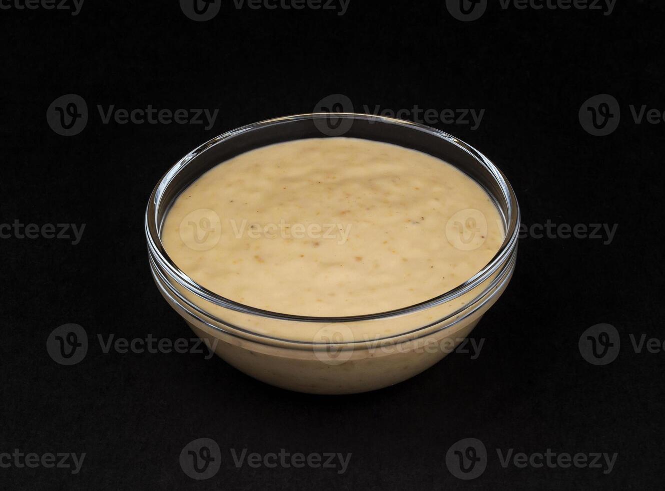 Erdnuss Soße. Tahini isoliert auf schwarz Hintergrund foto