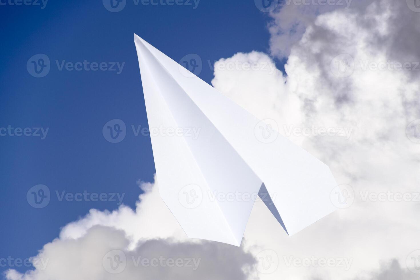 Weiß Papier Flugzeug im ein Blau Himmel mit Wolken. das Botschaft Symbol im das Bote foto