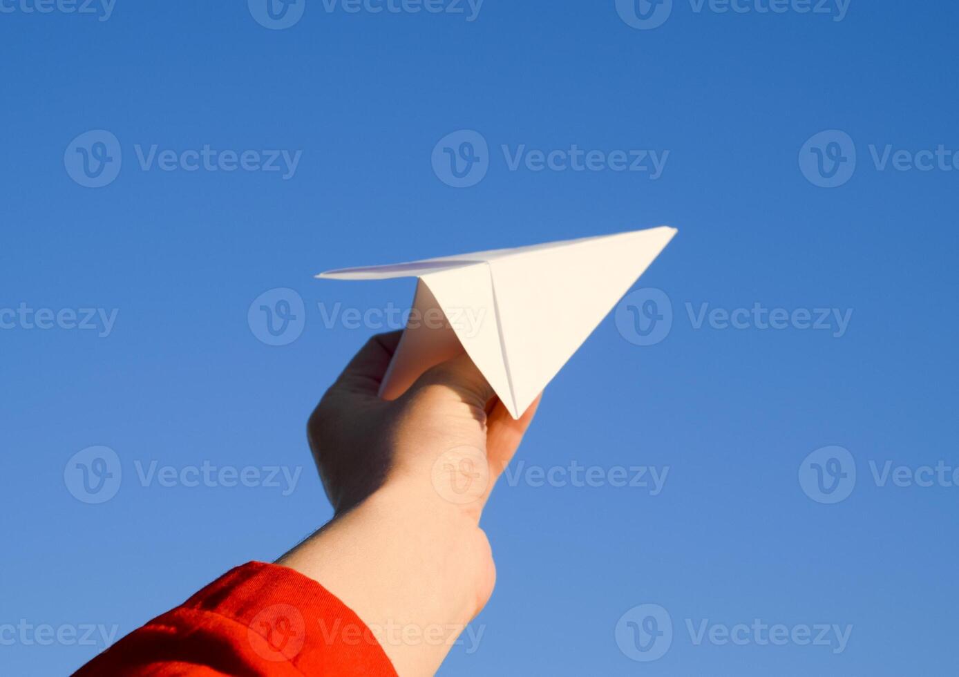 Weiß Papier Flugzeug im Hand gegen das Himmel. ein Symbol von Freiheit auf das Internet foto