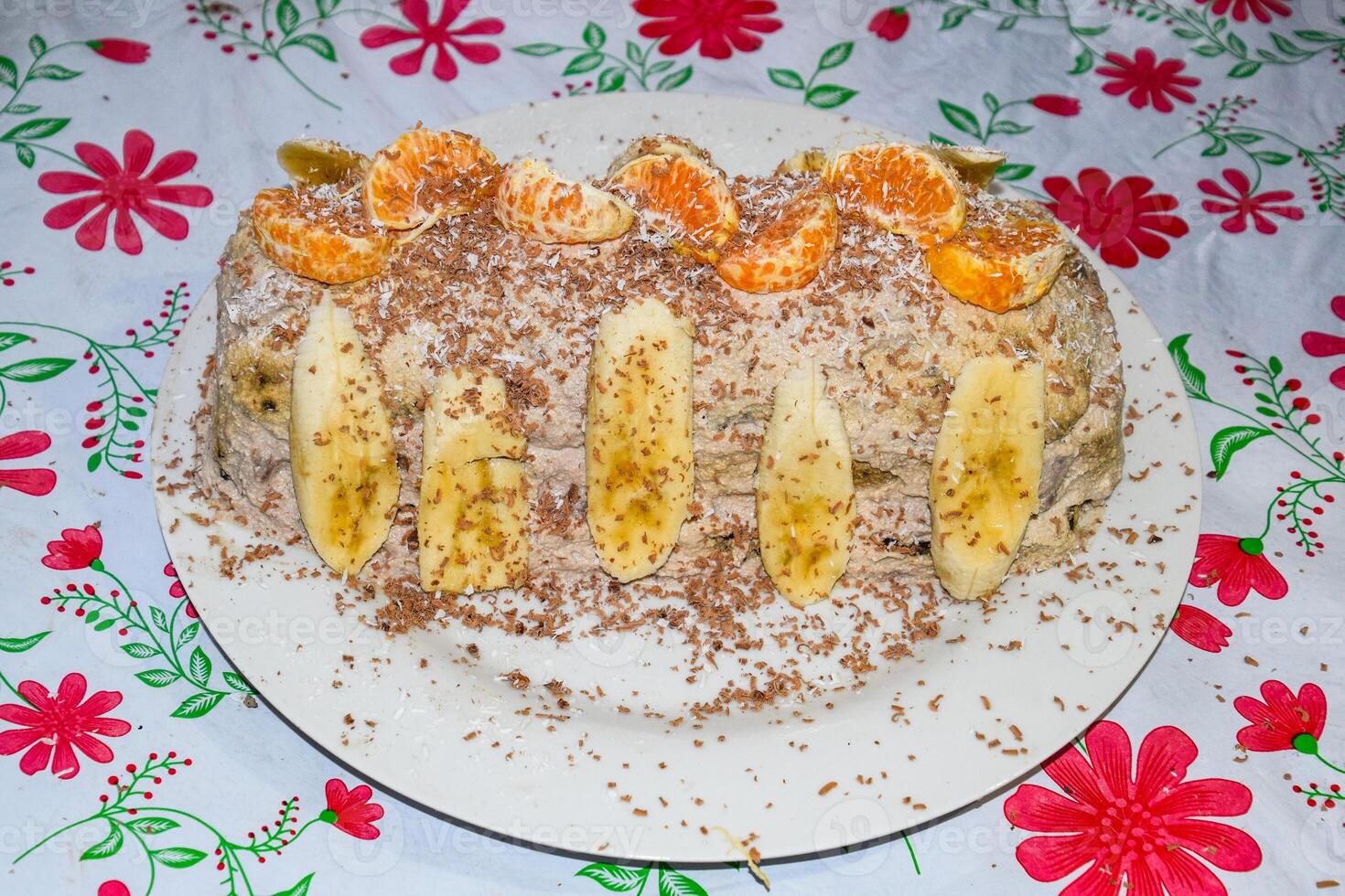 Kuchen mit Banane und Mandarinen, bestreut mit Schokolade. foto