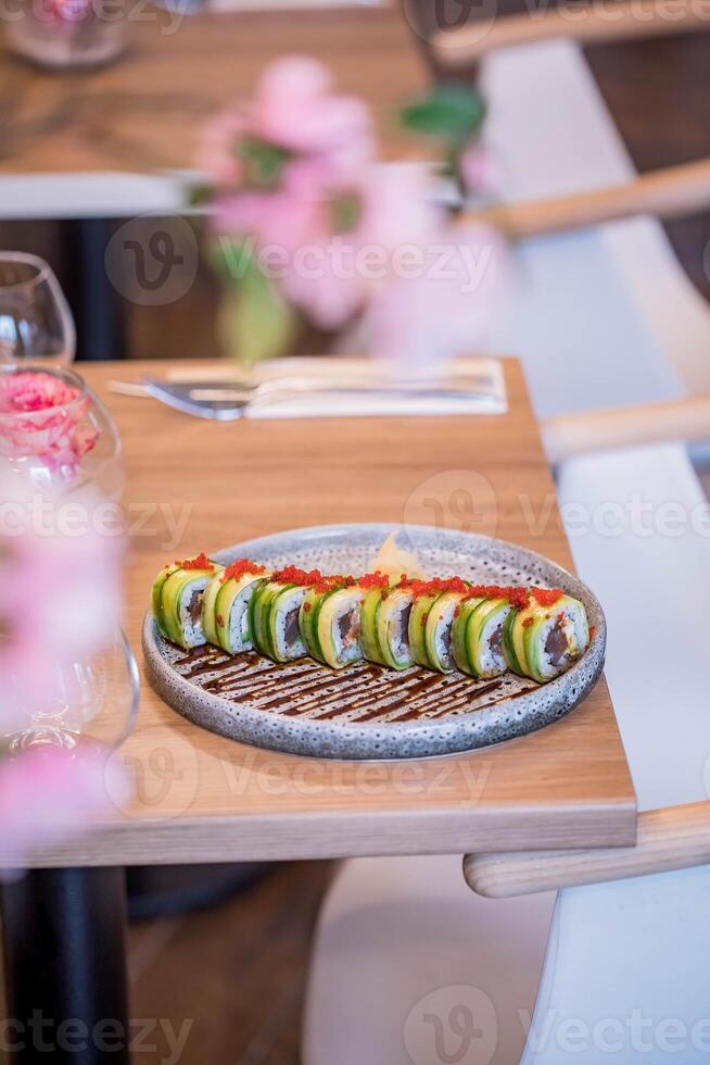 Sushi Rollen auf ein hölzern Tabelle im ein Restaurant. selektiv Fokus foto