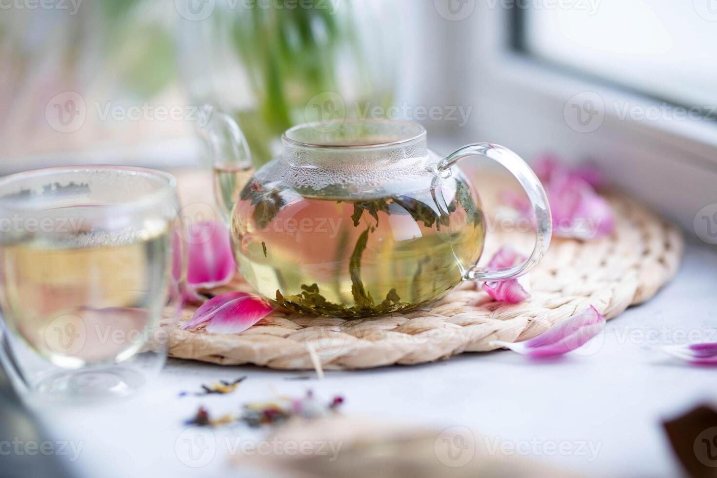 Grün Tee im ein Glas Teekanne auf das Fensterbrett. foto