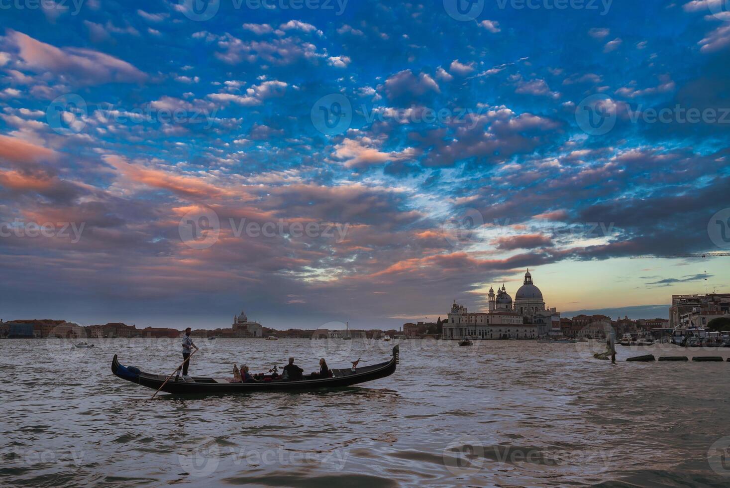 traditionell venezianisch Gondel schwebend auf heiter Wasser mit Stadt Horizont im Hintergrund foto