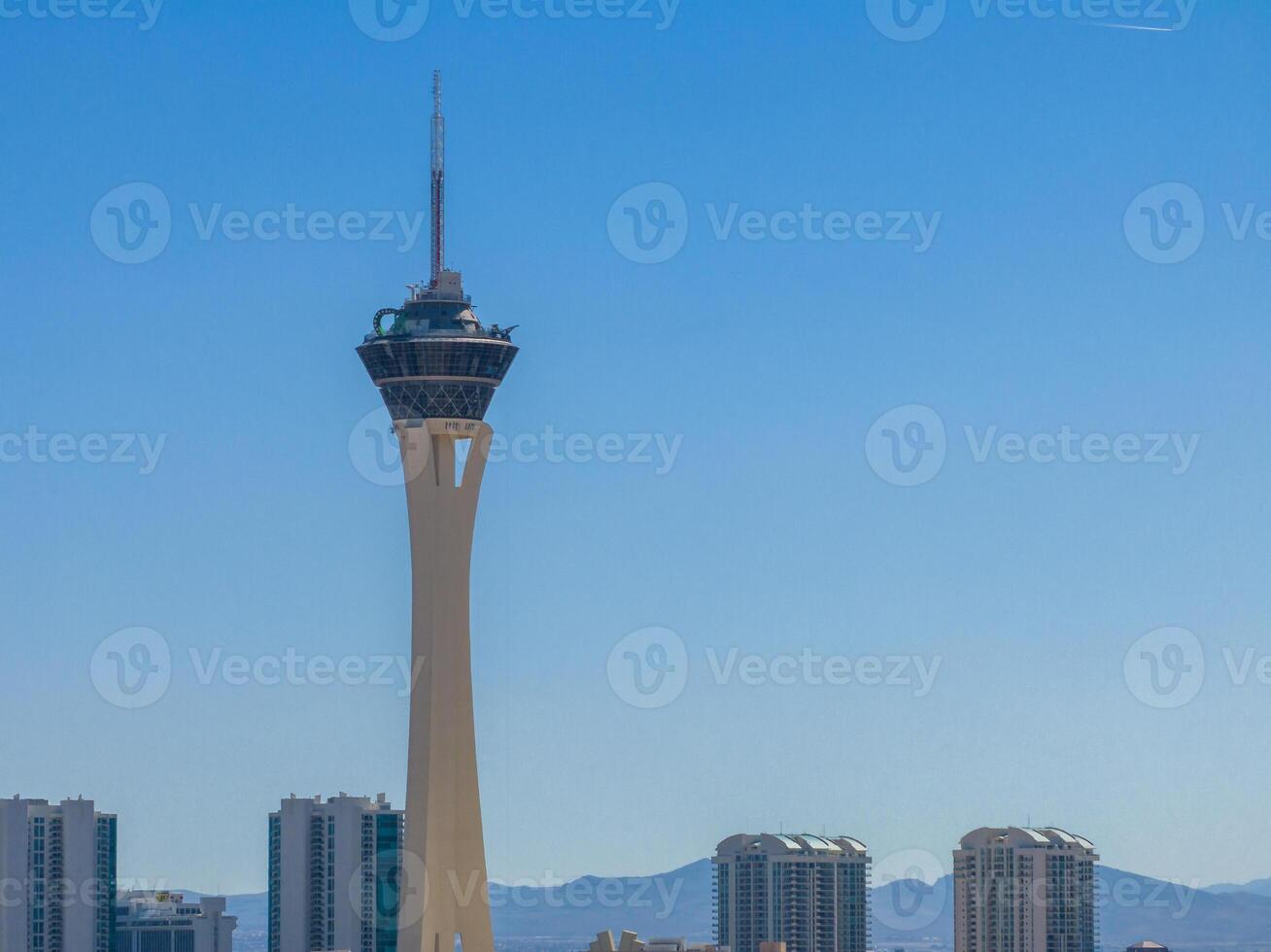 modern Stratosphäre Turm dominiert las Vegas Horizont inmitten Blau Himmel und Hochhäuser foto