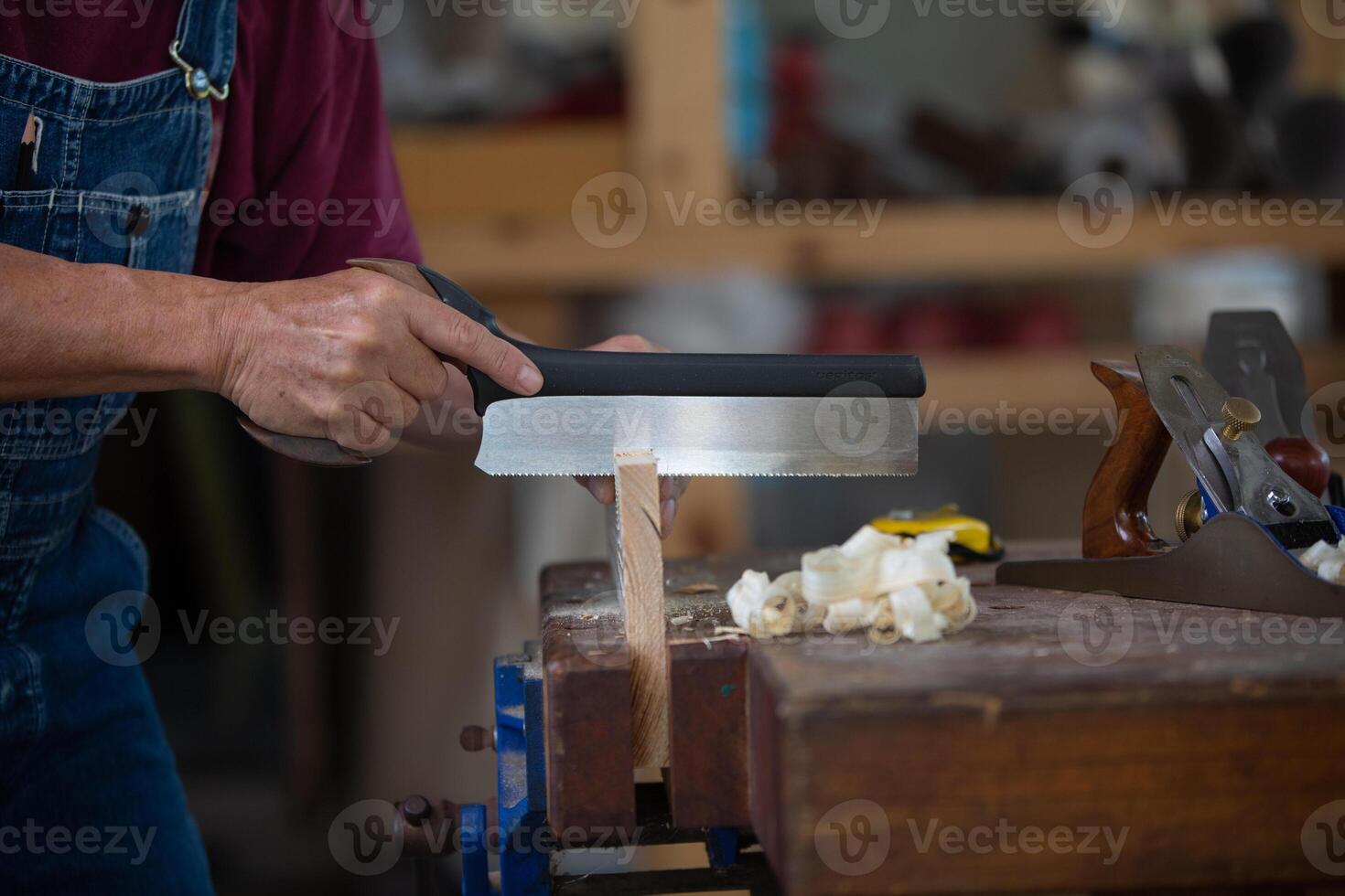 Zimmermann Arbeiten mit Ausrüstung auf hölzern Tisch. Zimmermann Arbeiten auf Holzbearbeitung Maschinen im Zimmerei Geschäft. Mann funktioniert im ein Zimmerei Geschäft. foto