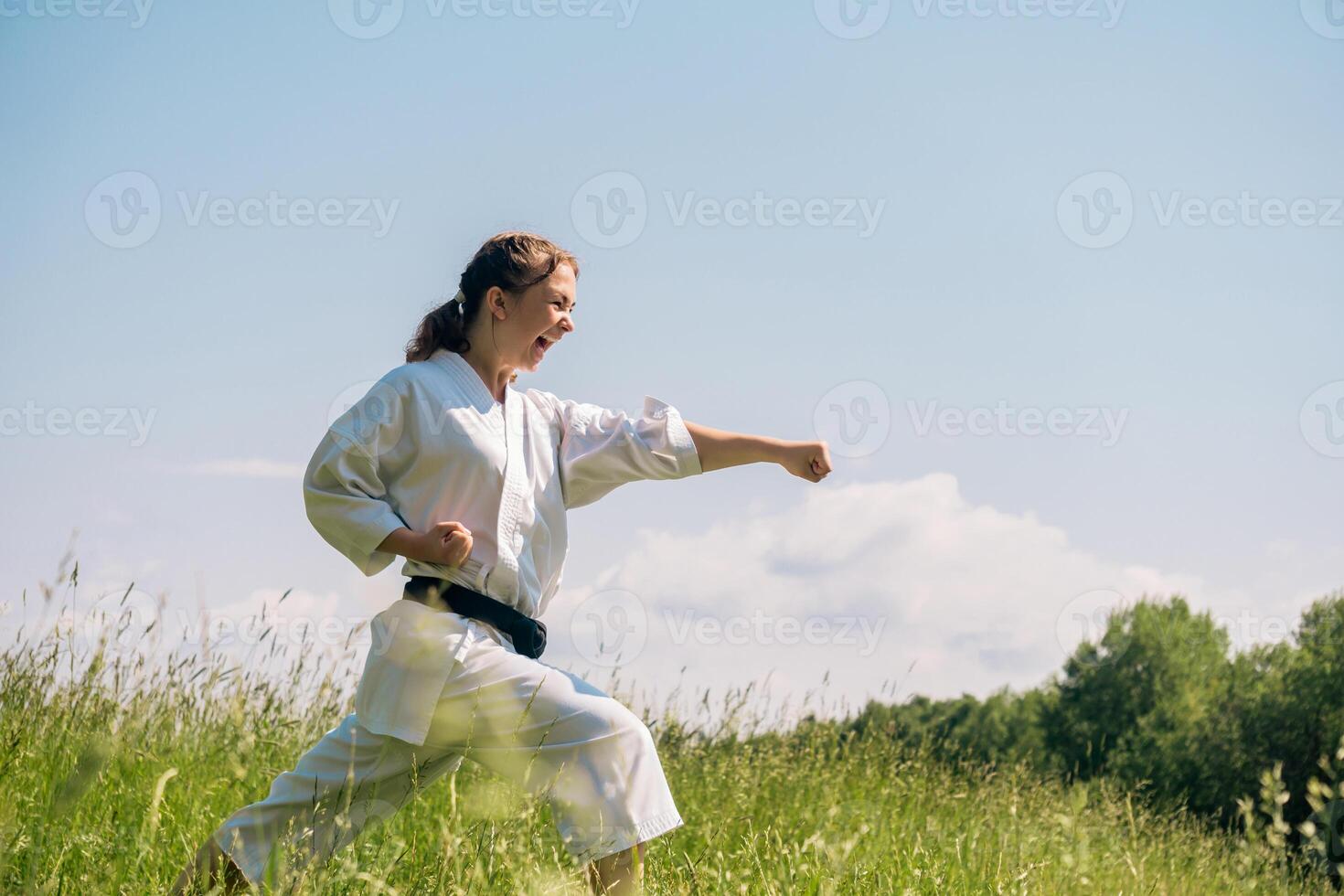 Teen Mädchen Ausbildung Karate Kata draußen, durchführen ein Streik oi zuki mit Kiai foto