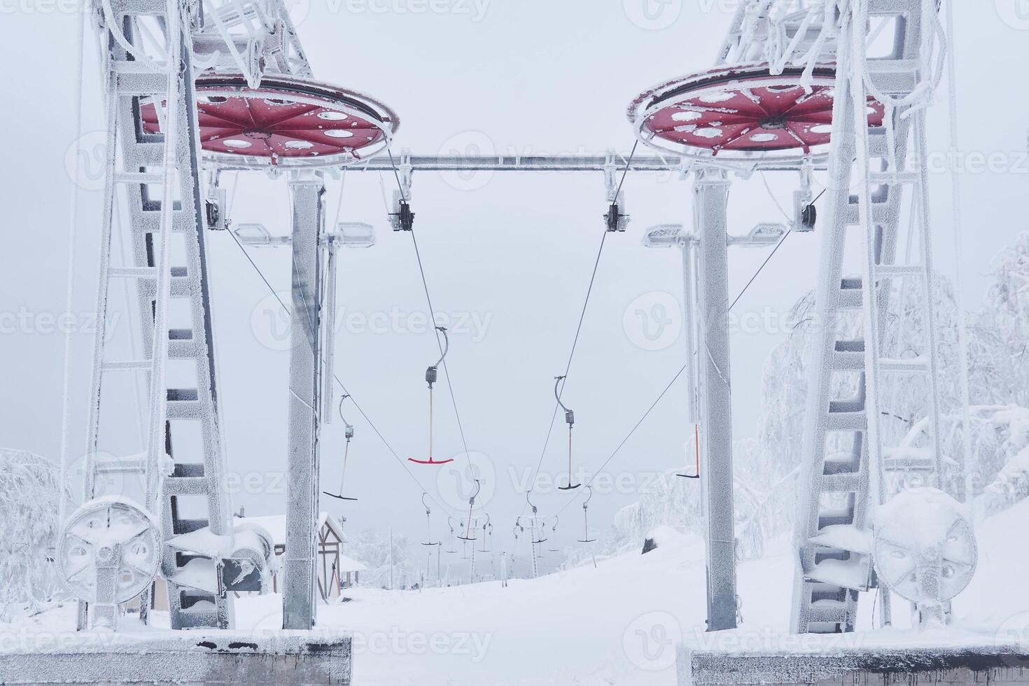 Oberer, höher Bahnhof von das Ski Aufzug auf ein schneebedeckt Hügel unter eisig Bäume foto