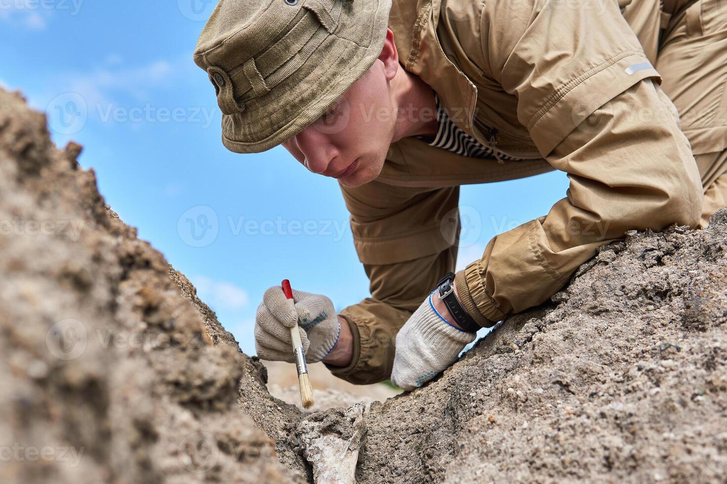 Mann Archäologe vorsichtig reinigt das finden mit ein Bürste foto