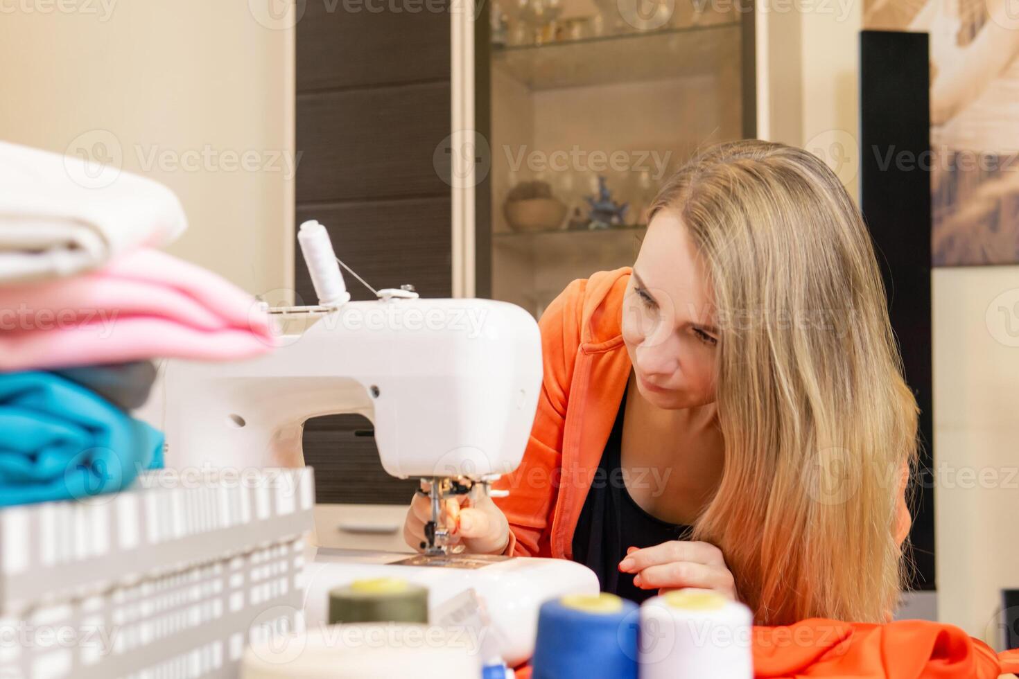 Näherin Einfädeln das Nadel von ein Nähen Maschine foto