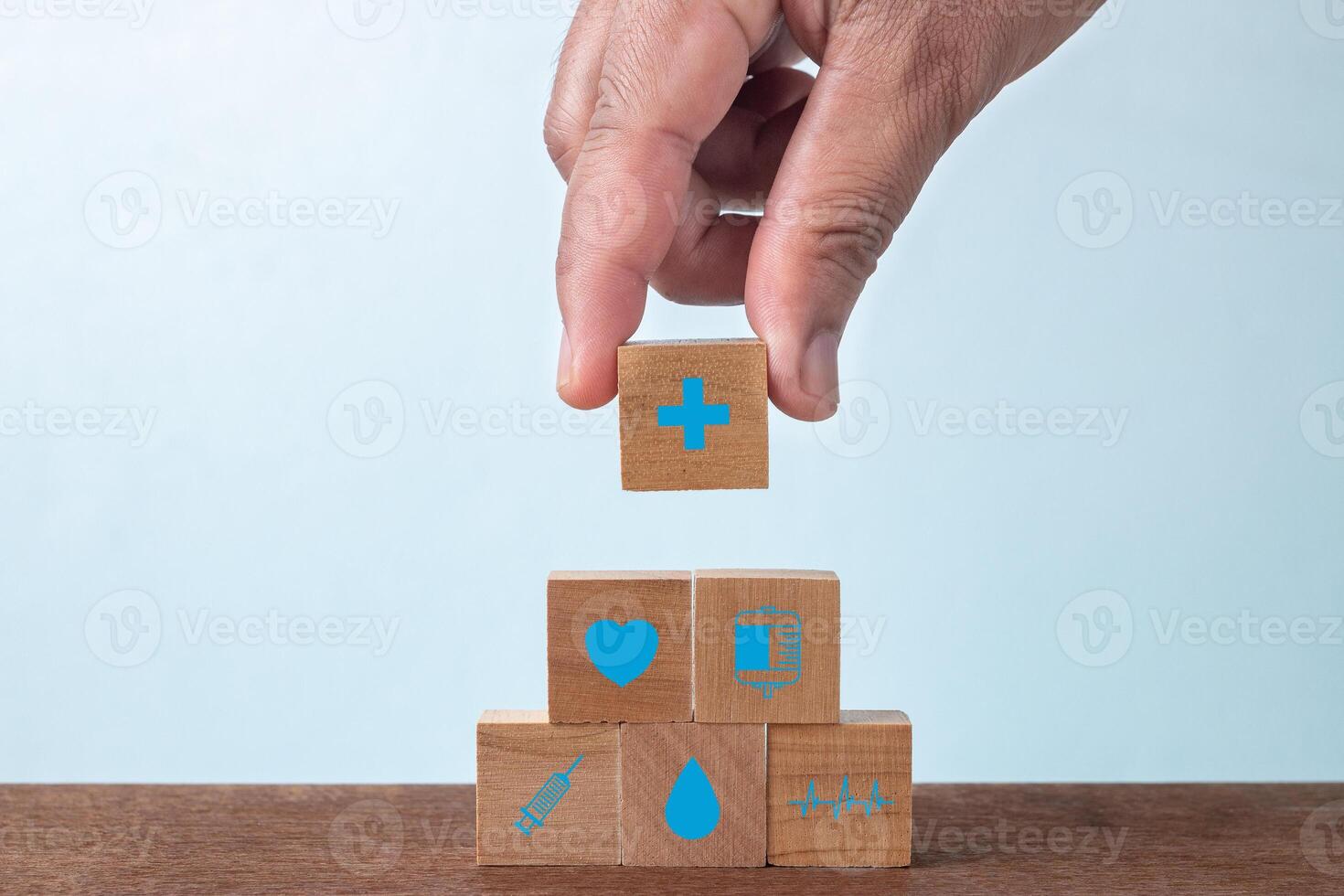 Versicherung zum Ihre Gesundheit und Gesundheitswesen Konzept, Geschäftsmann Hand arrangieren Holz Block Stapeln mit Symbol Gesundheitswesen medizinisch. foto