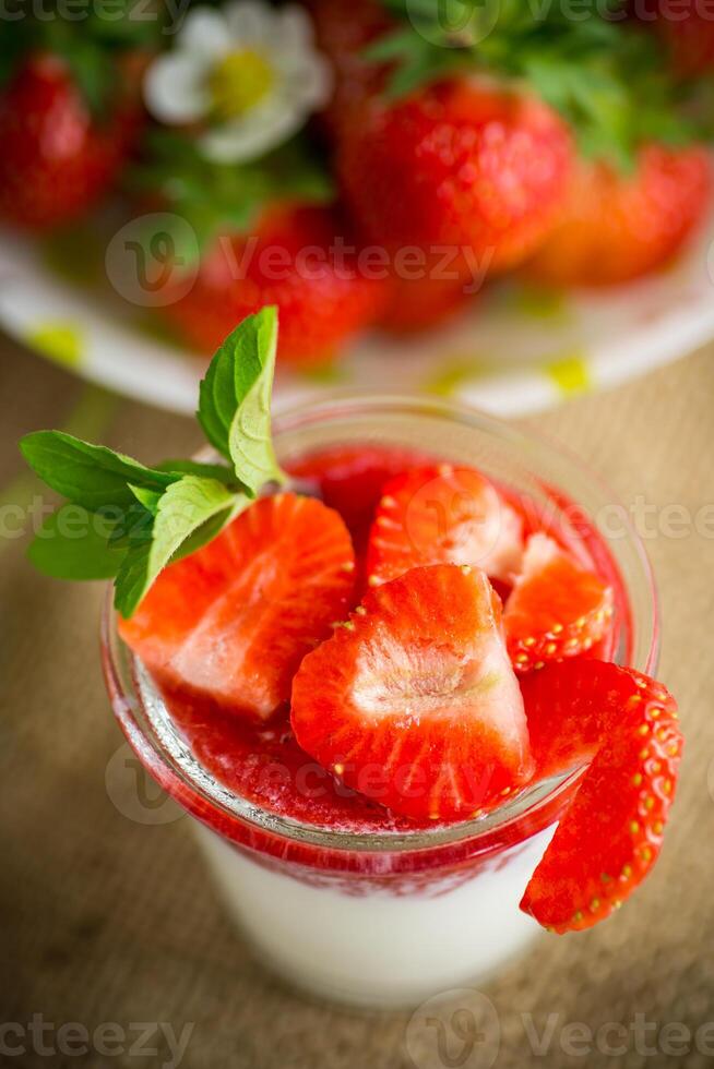 Süss hausgemacht Joghurt mit Erdbeere Marmelade und frisch Erdbeeren im ein Glas Tasse foto