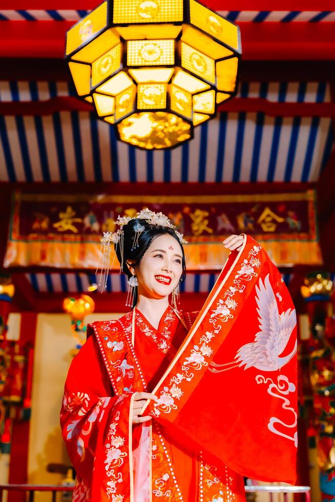 Frau Kleid China Neu Jahr. Porträt von ein Frau. Person im traditionell Kostüm. Frau im traditionell Kostüm. schön jung Frau im ein hell rot Kleid und ein Krone von Chinesisch Königin posieren. foto