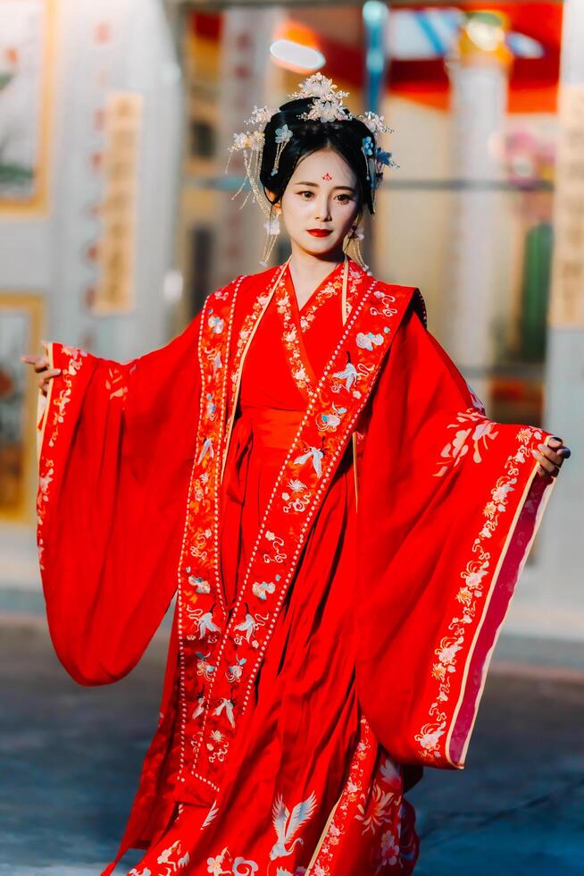 Frau Kleid China Neu Jahr. Porträt von ein Frau. Person im traditionell Kostüm. Frau im traditionell Kostüm. schön jung Frau im ein hell rot Kleid und ein Krone von Chinesisch Königin posieren. foto