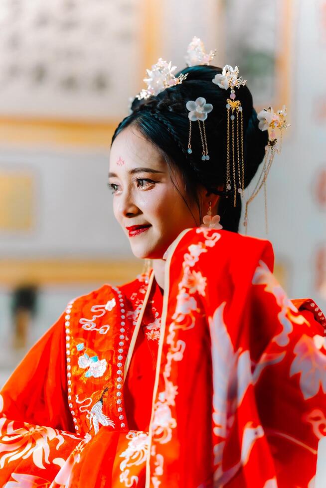 Frau Kleid China Neu Jahr. Porträt von ein Frau. Person im traditionell Kostüm. Frau im traditionell Kostüm. schön jung Frau im ein hell rot Kleid und ein Krone von Chinesisch Königin posieren. foto